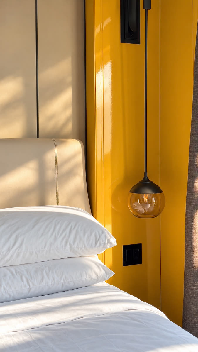 Yellow bedside wall with a pendant lamp
